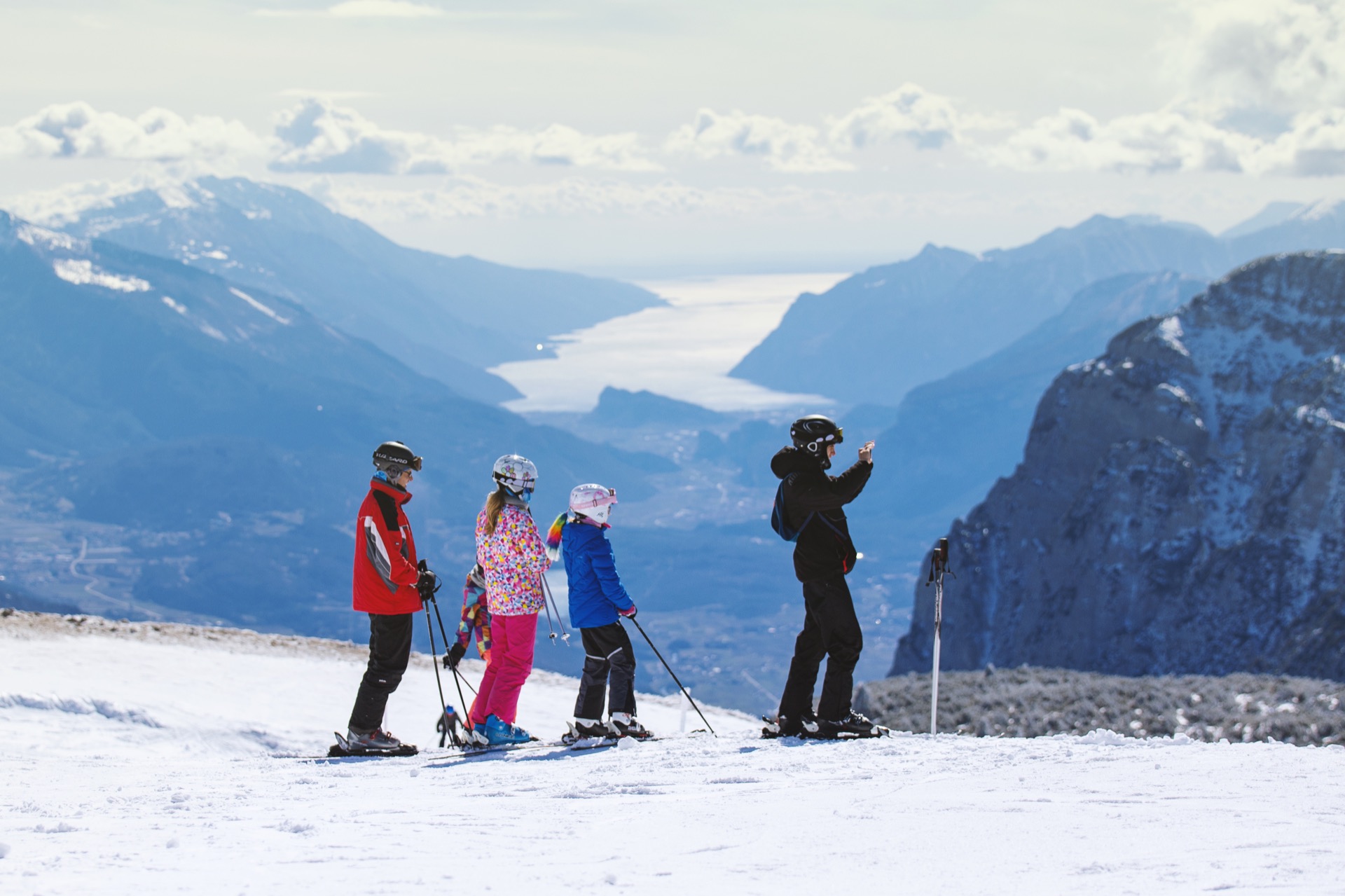 Eine Familie beim Skifahren mit dem See im Hintergrund